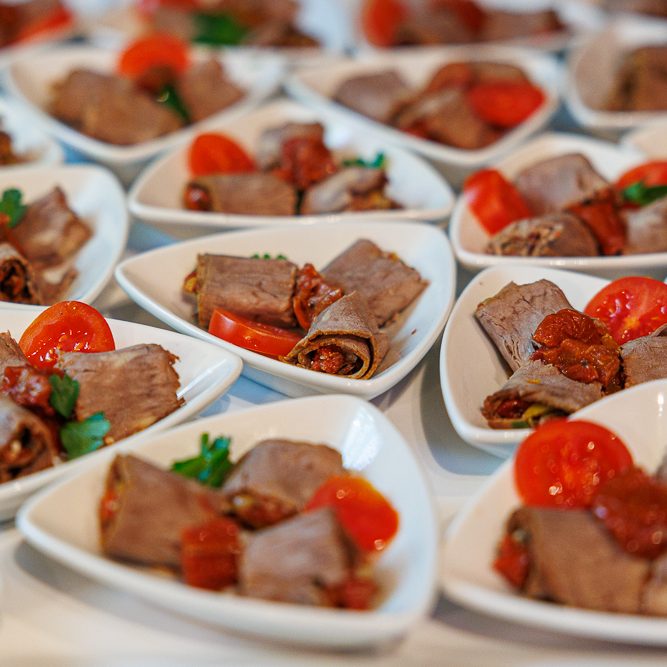 Vielfalt an Canapés und Häppchen auf Platten, serviert mit frischen Zutaten.