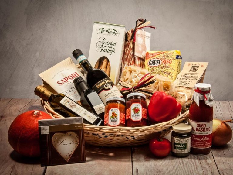 Ein Korb mit verschiedenen Lebensmitteln, einschließlich Marmelade, Saucen und Obst.