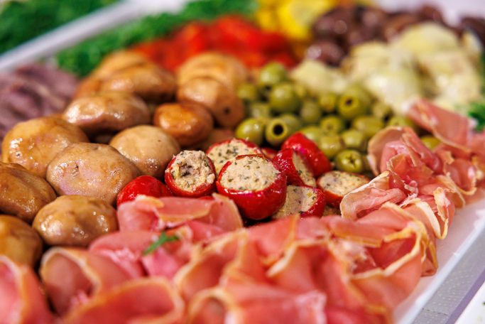 Bunte Platte mit Schinken, Oliven, Pilzen, Käse und frischem Gemüse.