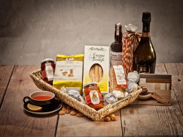 Ein Geschenkkorb mit Marmelade, Keksen, Getränken und einer Tasse.
