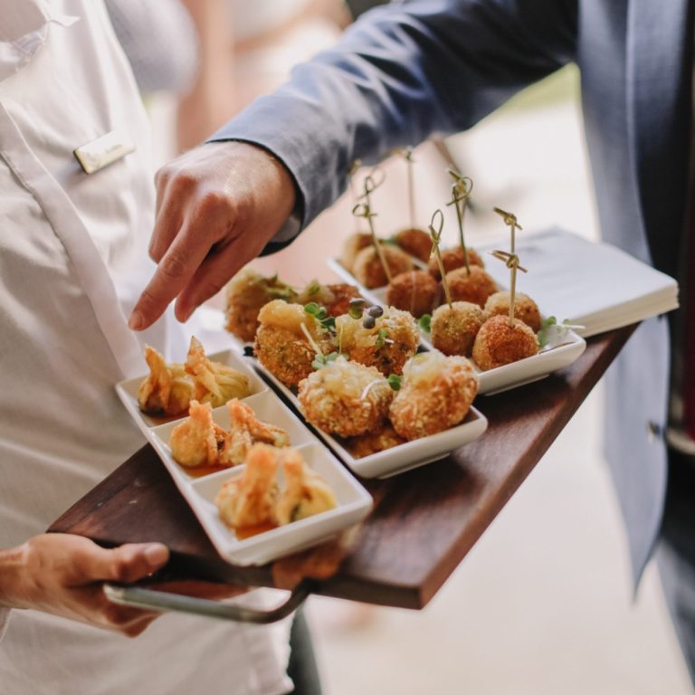Gedeckter Tisch mit verschiedenen frittieren Snacks auf Holztablett.